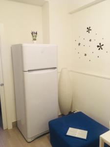 a white refrigerator in a room with a blue table at Around Cassaro Holiday House in Palermo
