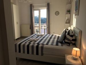 a bedroom with a bed with a striped blanket at Villa Bingo in Cavtat