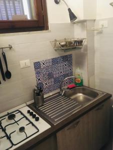 a small kitchen with a sink and a stove at Around Cassaro Holiday House in Palermo