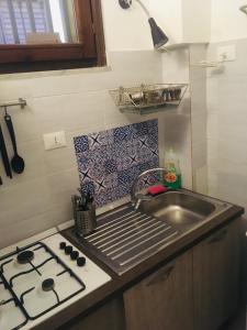 małą kuchnię ze zlewem i kuchenką w obiekcie Around Cassaro Holiday House w mieście Palermo +31 zdjęć