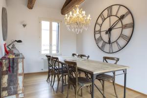 a dining room with a table and a large clock on the wall at Terrazza Rialto in Venice