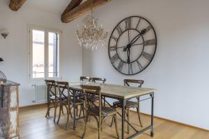 comedor con mesa y reloj grande en la pared en Terrazza Rialto, en Venecia