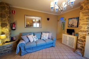 a blue couch in a living room with a mirror at La Vista de Medina Studios & Apartments in Medina Sidonia