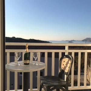 einen Tisch mit einer Flasche Wein und einen Stuhl auf dem Balkon in der Unterkunft Villa Bingo in Cavtat