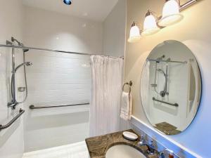 a bathroom with a shower and a sink and a mirror at Inn on Main Hotel in Manasquan