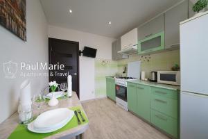 a kitchen with green cabinets and a white refrigerator at PaulMarie Apartments on Shahterov in Salihorsk