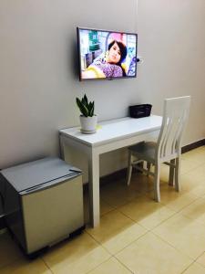Elle comprend un bureau avec une télévision murale et une chaise. dans l'établissement Hotel Mini, à Phú Thọ