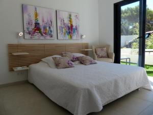 a bedroom with a large bed with two pillows at Villa Laricio in Bonifacio +50 photos