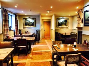 ein Restaurant mit Holztischen und Stühlen in der Unterkunft The Moon Inn at Stoney Middleton in Stony Middleton