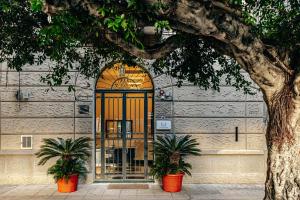 una porta per un edificio con due piante davanti di Giulio Cesare 14, Residence a Palermo