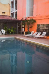 a swimming pool with lounge chairs next to a building at Hotel Plaza Independencia in Villahermosa