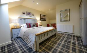 a hotel room with a bed and a dresser at The Moon Inn at Stoney Middleton in Stony Middleton