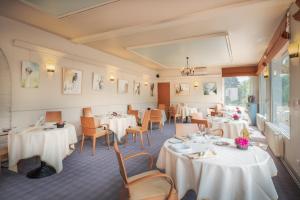 een eetkamer met witte tafels en stoelen bij Logis Hôtel Restaurant Le Coq Hardi in Pouilly-sur-Loire