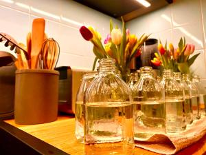 een groep glazen flessen op een toonbank met bloemen bij Seerose Boutique-Pension in Tating