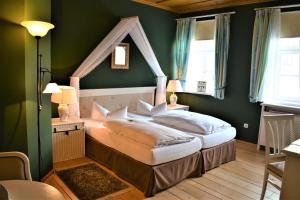 a bedroom with a bed in a green room at Die Kronacher Stadthotels in Kronach