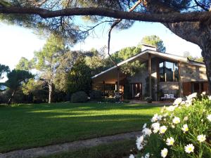 ein Haus mit einem grünen Garten mit Blumen in der Unterkunft Les Margarides in Seva