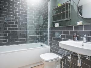 La salle de bains est pourvue de toilettes blanches et d'un lavabo. dans l'établissement New modern Apt in the City & close to Stadiums, à Cardiff