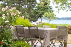 una mesa con cuatro sillas sentadas a su alrededor en Rêves de bord de mer, en Locmariaquer