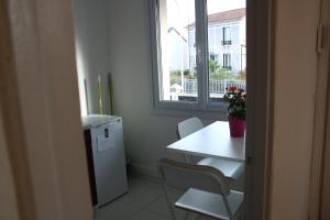 una piccola cucina con tavolo e finestra di COSY HOME APPART entre Paris et Disney Land a Fontenay-sous-Bois Altre 10 foto