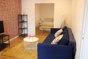 un soggiorno con un divano blu e un letto di COSY HOME APPART entre Paris et Disney Land a Fontenay-sous-Bois