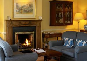 a living room with two chairs and a fireplace at The Dunraven, Adare in Adare