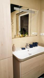 a bathroom with a sink and a mirror at Südländische Flair in Neubiberg
