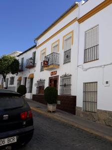 a car parked in front of a white building at Apartamento Casa Romero in El Bosque