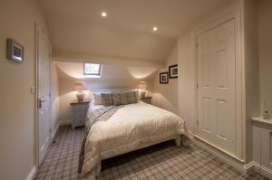 a bedroom with a bed and a dresser at The Moon Inn at Stoney Middleton in Stony Middleton