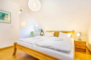 - une chambre avec un grand lit et des draps blancs dans l'établissement Natourlust Preetz - Die große Grüne, à Burtevitz