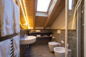 a bathroom with a sink and a toilet and a window at Relax Hotel Erica in Asiago