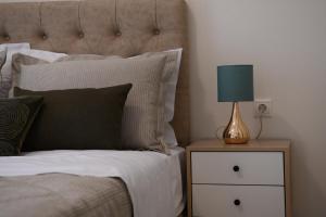 una cama con una lámpara azul en una mesita de noche en Anemi Deluxe Apartment, en Kolios