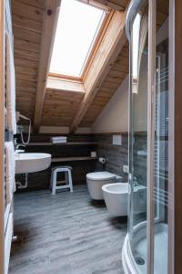 a bathroom with two sinks and two tubs and a window at Relax Hotel Erica in Asiago