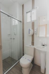 a white bathroom with a toilet and a sink at Hotel Aixo Suites By GEH Suites in Cartagena de Indias