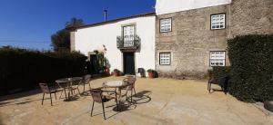 un patio con tavoli e sedie di fronte a un edificio di Quinta Sao Miguel de Arcos a Vila do Conde