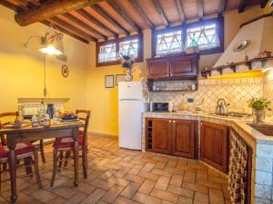 uma cozinha com uma mesa e um frigorífico branco em Holiday Home Capanna di Sotto by Interhome em Villa Bertolli