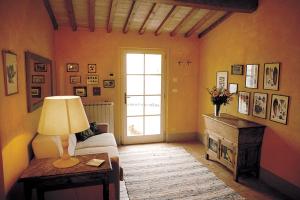 sala de estar con sofá y mesa con lámpara en Agriturismo Fattoria Santa Vittoria, en Pozzo