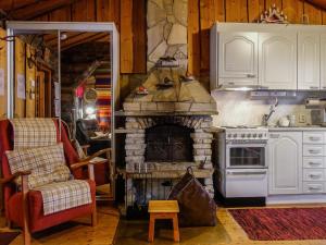ルオストにあるHoliday Home Hopukka a2 by Interhomeの石造りの暖炉と椅子付きのキッチン