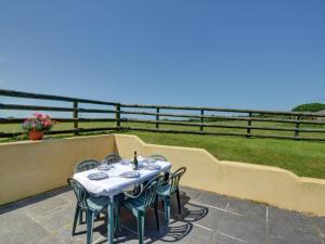a table and chairs on a balcony with the ocean at Holiday Home Travenna by Interhome in Saint Mawgan