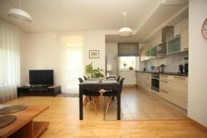 a kitchen with a table and a dining room at Cozy Home Apartment Kaivas, free parking, self check-in in Riga