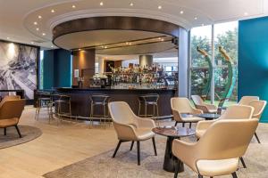 un bar dans un restaurant avec des chaises et un comptoir de bar dans l'établissement Best Western Plus Hotel Admiral, à La Tour-de-Salvagny