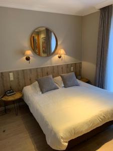a bedroom with a large bed and a mirror at Hotel Ter Duinen in Bruges
