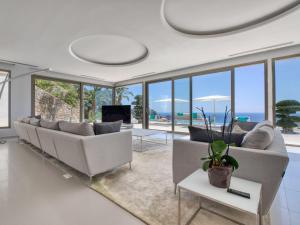 a living room with white furniture and glass windows at Villa Emma on the Roc by Interhome in Jávea