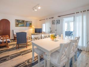 a dining room and living room with a white table and chairs at Apartment Voramar by Interhome in Alcudia