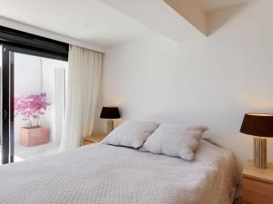 - une chambre blanche avec un lit et une fenêtre dans l'établissement Holiday Home Les Arbousiers by Interhome, à La Nartelle