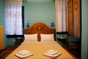 House Mitsiou Traditional Inn في أرنايا: غرفة نوم عليها سرير وفوط