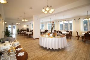 a dining room with a table with a white table cloth at Dwór i Dworek Leszczowate Wellness & Spa in Ustrzyki Dolne