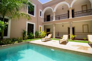 a villa with a swimming pool and a house at Hotel Merida in Mérida