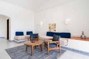 a living room with a couch and a table and chairs at Apartamentos Borda D´Agua in Albufeira
