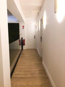 a hallway with a white door and wooden floors at Suites Hom Sevilla in Seville