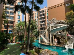 - une piscine dans un complexe avec des personnes jouant dans l'eau dans l'établissement Atlantis Condo Resort Pattaya, à Jomtien Beach